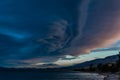 Colorful bright pink sunset with blue clouds on pebble shore of bay of lake baikal with trees Royalty Free Stock Photo