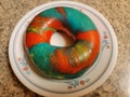 colorful bright rainbow bagel with many colors on plate Royalty Free Stock Photo