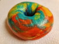 colorful bright rainbow bagel with many colors on counter Royalty Free Stock Photo