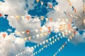 Colorful bright triangular Bunting flags on a blue sky background with white clouds. concept of celebration and fun Royalty Free Stock Photo