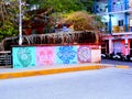 Colorful building and street mural of tribal art on bridge in sayulita amongst tropical plants
