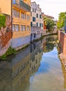 Colorful buildings, architecture, water reflections on city canal and old facade with blue sky in Padua Veneto, italy Royalty Free Stock Photo