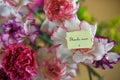 Colorful bunch of spring carnation flowers and miniature note for thank you mum