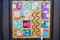 Colorful busy Board made of wood with a lot of different things on it. developing children`s game for motor skills of the kid. nob