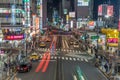 Colorful busy Street, Neon Billboards, Car trails and Motion blurred People passing along Shops around Shinjuku Station