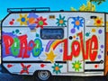 Colorful camper with flowers and the text ''peace and love'' on the street