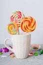 Colorful candies in cup on table on light background background. Large swirled lollipops. Creative concept of a jar full Royalty Free Stock Photo