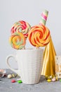 Colorful candies in cup on table on light background background. Large swirled lollipops. Creative concept of a jar full Royalty Free Stock Photo