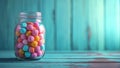 Colorful candies in glass jar on wooden background