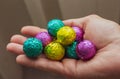 Colorful candies in hands, top view. Chocolate easter eggs in hands. Easter symbol. Sweet food concept. Hands holding sweets.