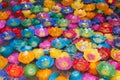 Colorful candle krathong floats in water.