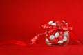 Colorful candy jar decorated with a red bow with hearts on red background. Valentines day concept Royalty Free Stock Photo