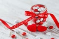 Colorful candy jar decorated with a red bow with hearts on white wooden background. Valentines day concept Royalty Free Stock Photo