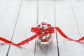 Colorful candy jar decorated with a red bow with hearts on white wooden background. Valentines day concept Royalty Free Stock Photo