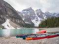 Canoes on the shore of Moraine Lake surrounded by snowy hills in Canada Royalty Free Stock Photo