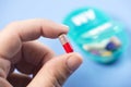 Colorful Capsule In Patient Hand With Daily Pill Dispenser