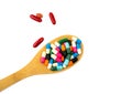 Colorful of capsule pills in wooden spoon are spilling isolated on white background with copy space and clipping path. Royalty Free Stock Photo