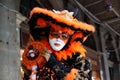 Colorful carnival black-orange-gold mask and costume at the traditional festival in Venice, Italy