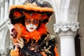 Colorful carnival black-orange mask and costume at the traditional festival in Venice, Italy