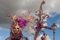 Colorful carnival mask against a dramatic sky during a parade in Castiglion Fibocchi, Arezzo, Italy