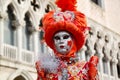 Colorful carnival orange-silver mask and costume at the traditional festival in Venice, Italy