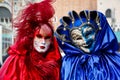 Colorful carnival pair red-blue mask and costume at the traditional festival in Venice, Italy