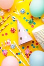 Colorful carnival or party frame of balloons, streamers and confetti on yellow background. Vertical photo Royalty Free Stock Photo