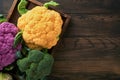 Colorful cauliflower. Various sort of cauliflower on old wooden background. Purple, yellow, white and green color cabbages. Royalty Free Stock Photo