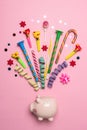 Colorful celebration background with piggy bank, various party confetti, streamers and decoration. Minimal party concept. Flat lay