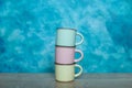 colorful ceramic bowls and coffee cups and teapot on a table against blue background. space for text Royalty Free Stock Photo