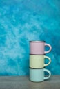 colorful ceramic bowls and coffee cups and teapot on a table against blue background. space for text Royalty Free Stock Photo