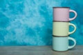 colorful ceramic bowls and coffee cups and teapot on a table against blue background. space for text Royalty Free Stock Photo