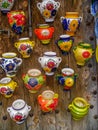 Colorful ceramic souvenirs hanging on wooden wall in spain