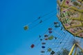 Colorful chain carousel in ride with ferris wheel in the background