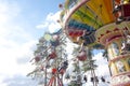 Colorful chain swing carousel in motion at amusement park on blue sky background.