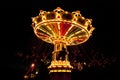 Colorful chain swing carousel in motion at amusement park at night. Royalty Free Stock Photo