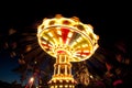 Colorful chain swing carousel in motion at amusement park at night.