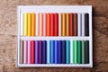 Colorful chalk pastels in box on wooden background Royalty Free Stock Photo