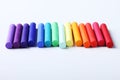 Colorful chalk pastels on white background arranged as rainbow