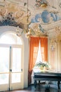 Colorful chandelier hangs from the painted ceiling of an ancient villa. Lake Como, Italy