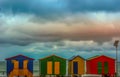 Colorful changing rooms in St James beach Cape Town under a cloudy sky and sunset