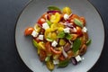 Colorful cherry tomatoes and basil salad in a plate, dark background. Healthy, summer food Royalty Free Stock Photo