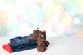 Colorful children jeans clothes. Fashionable red lined thermojeans and a trendy pair of blue sneakers on bright table over Royalty Free Stock Photo