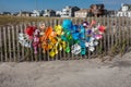 Colorful children`s beach sand toys that were left on the beach are displayed on a wooden fence at a beach entrance Royalty Free Stock Photo