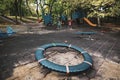 Colorful children`s playground with slides, swings and other objects in a public park with many trees around and no people Royalty Free Stock Photo