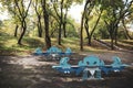 Colorful children`s playground with slides, swings and other objects in a public park with many trees around and no people Royalty Free Stock Photo