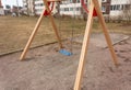 Colorful children`s swings on the playground in the courtyard of multi-storey buildings Royalty Free Stock Photo