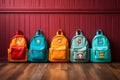 Colorful children schoolbags on a wooden floor, blue room backdrop