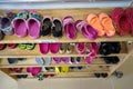 Colorful children shoes on rack in kindergarten