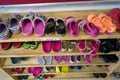 Colorful children shoes on rack in kindergarten